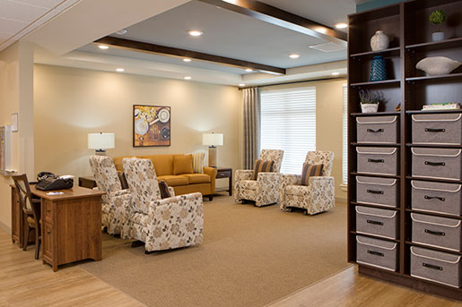 Warm, inviting seating area with floral armchairs, sofa, and decorative artwork.